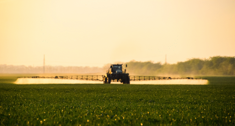a tractor sprays a field with chemicals
